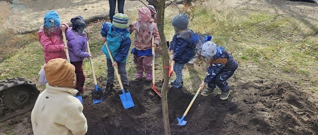 Die Kinder des Kindergarten Eden pflanzen Obstbäume